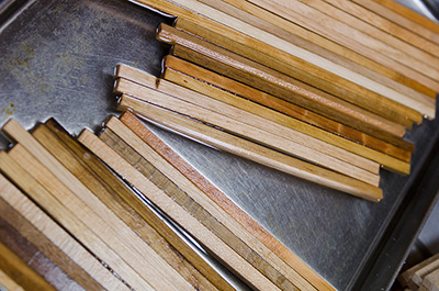 The chopstick blank is soaked in water, making them easier to cut by hand with a plane and knife.