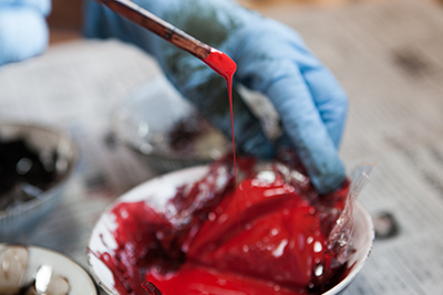 Minako mixing the urushi lacquer in a red colour.