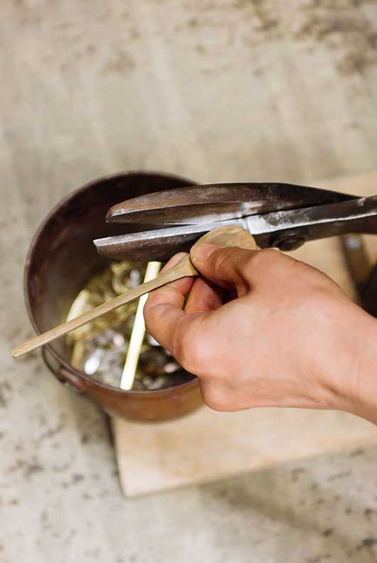 Cutting the spoon in to shape using a special set of metal cutters.