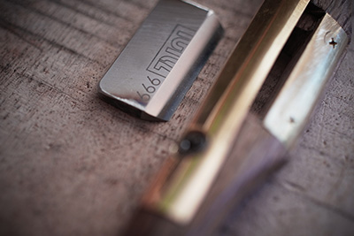 Up-close, the sharp bladed tool that he uses to shave the wood off.