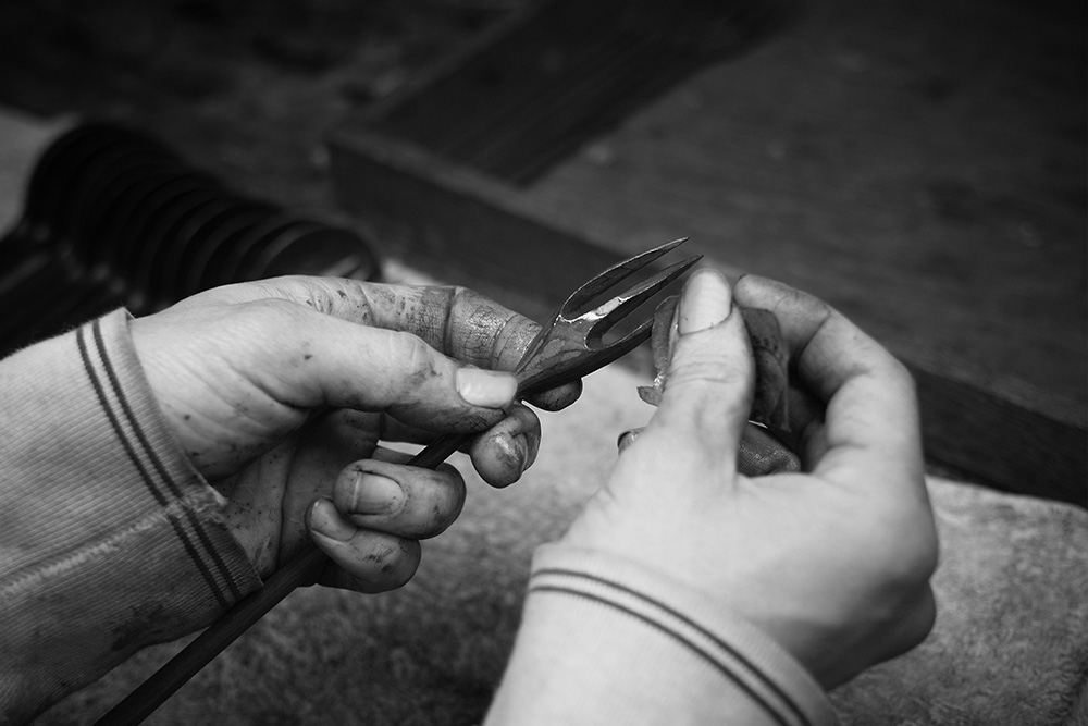 He adds the lacquer to the fork, it protects the wood and brings out all the surface marks.