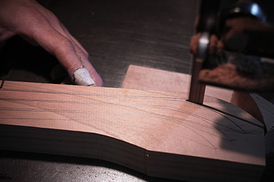He cuts around using a badnsaw where he has drawn on the wood, making sure he is as economical as possible.