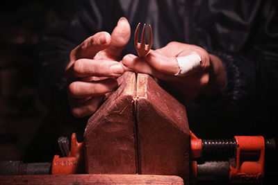 Hiroyuki puts the fork on a vice, making it easier to manipulate the wood and shave off any excess.