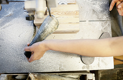 Sara cutting the horn on the band saw at Hornvarefabrikken's workshop in Bøvlingbjerg, Denmark.