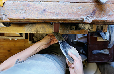 'Rubbing' a spoon means they grind it to a uniform thickness using very course sandpaper.