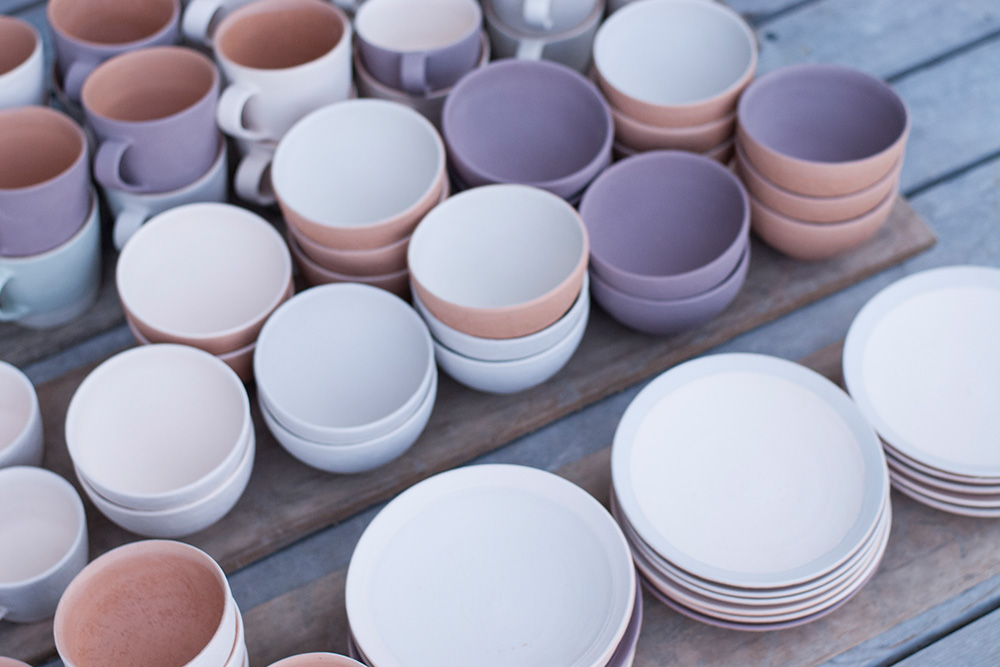 Different coloured pots that are waiting to be loaded in to the kiln.