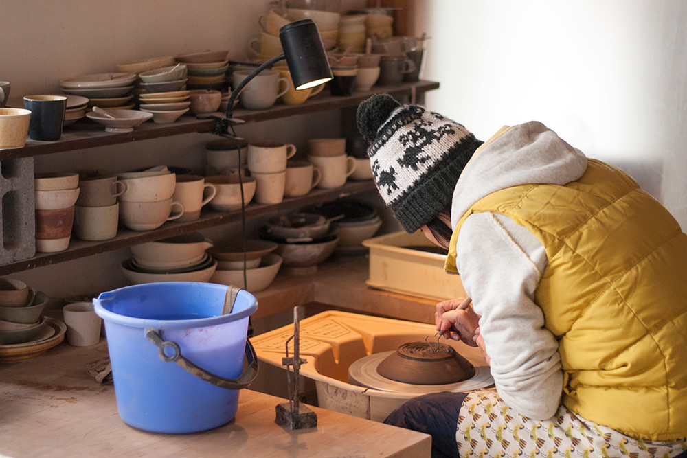 Satoko starts to trim the pottery of the bowl, getting rid of the excess clay left from the throwing process.