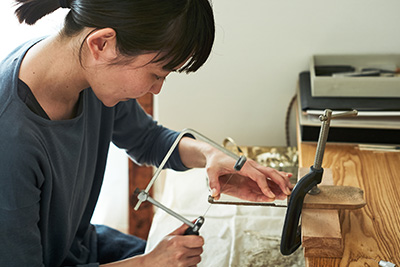 Using a small hacksaw to cut the metal.