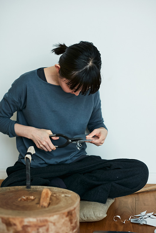 Naho Kamada cuts the metal by hand.