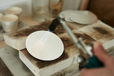 Using a blow torch to heat up the surface of the metal.