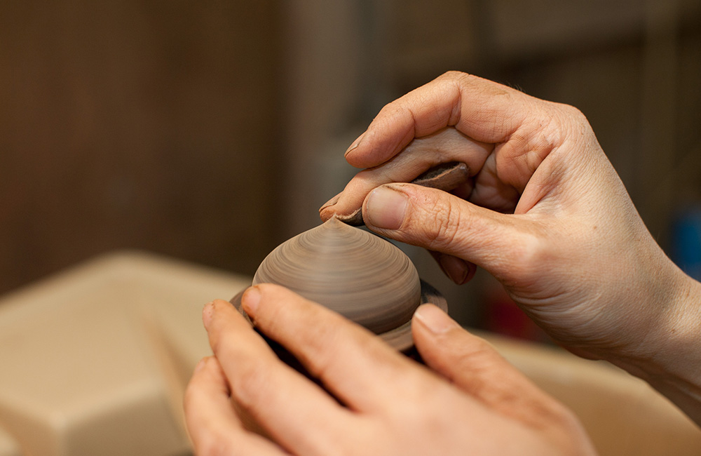 Maiko adds the first coat of lacquer to the Zelkova Dome Box, sanding the surface to get each layer evenly spread.