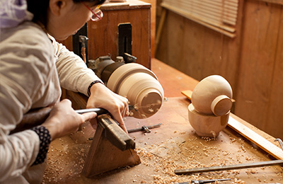 Japanese Woodturner Maiko Okuno crafting a wooden bowl on the lathe.