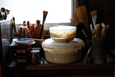 Makoto Asebi's brushes and slip in which he uses to sign his name and decorate his work.