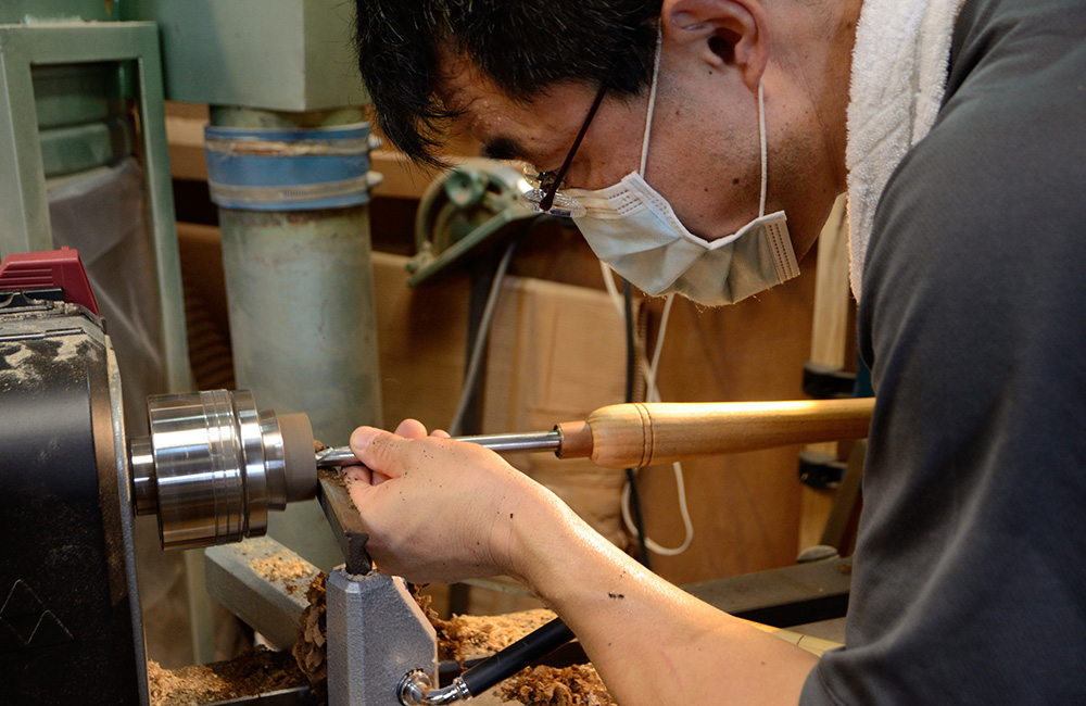 Yusuke Tazawa on the lathe turning the walnut coffee scoop to the desired shape.